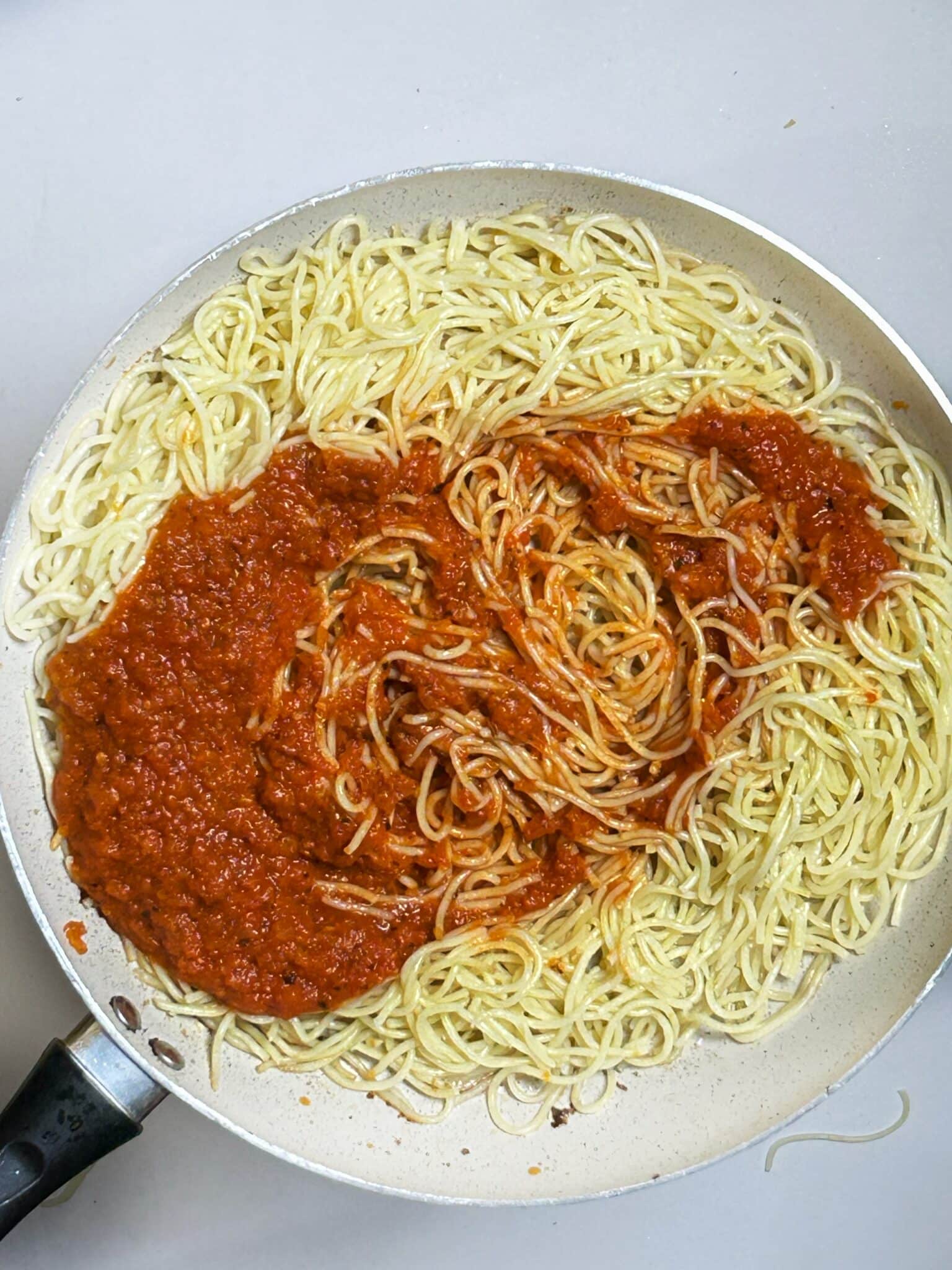 adding sauce in boiled pasta adding sauce in boiled pasta