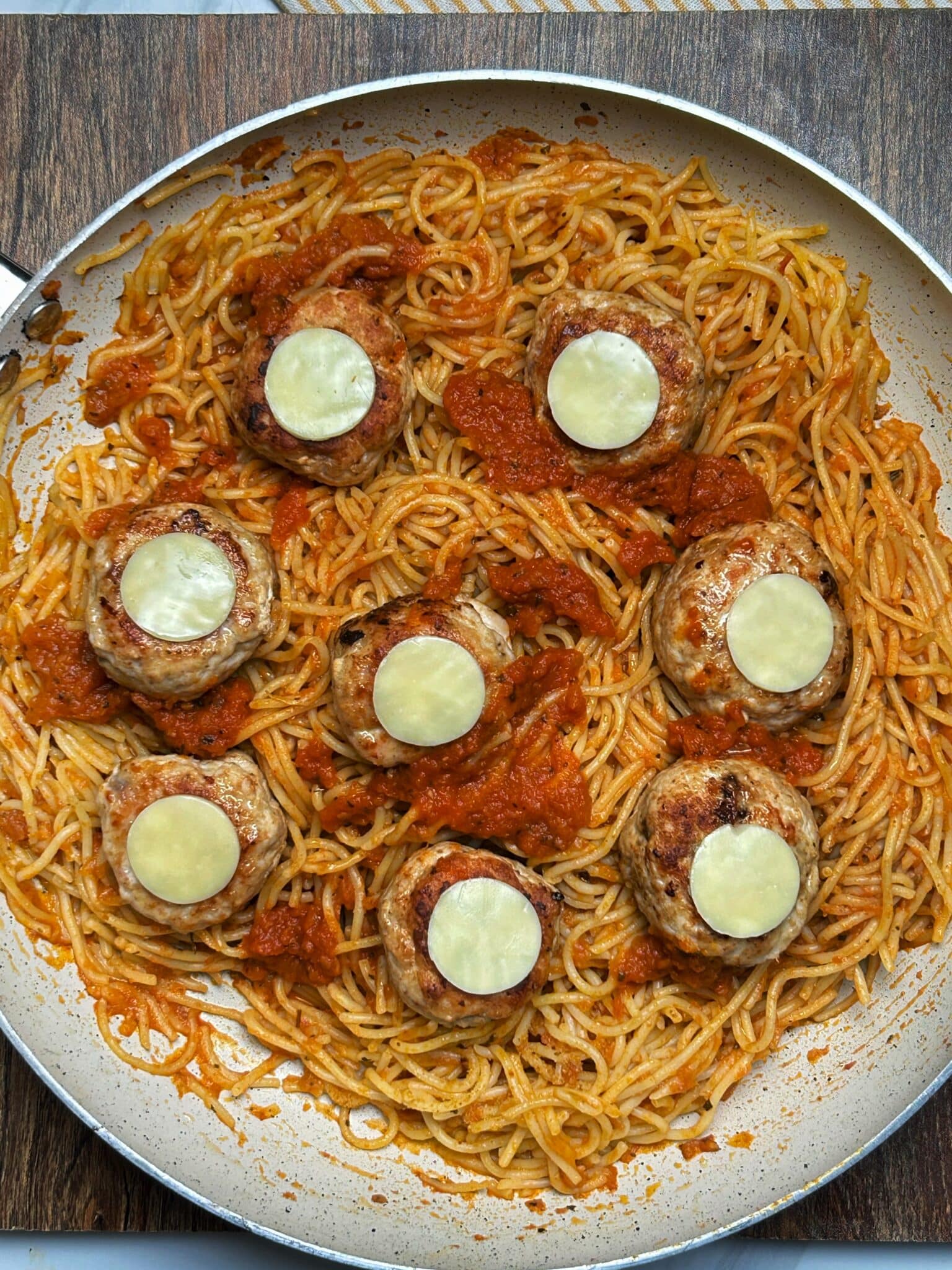 adding meatballs to pasta and topping it with cheese adding meatballs to pasta and topping it with cheese
