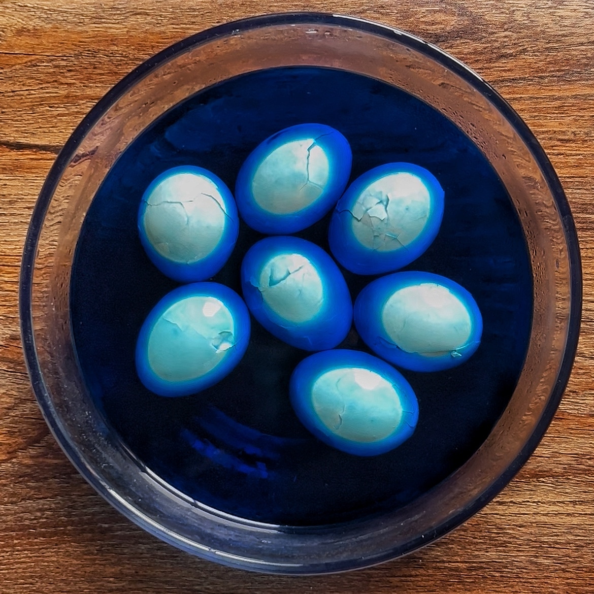 Cracked eggs in colored water with blue food dye Cracked eggs in colored water with blue food dye