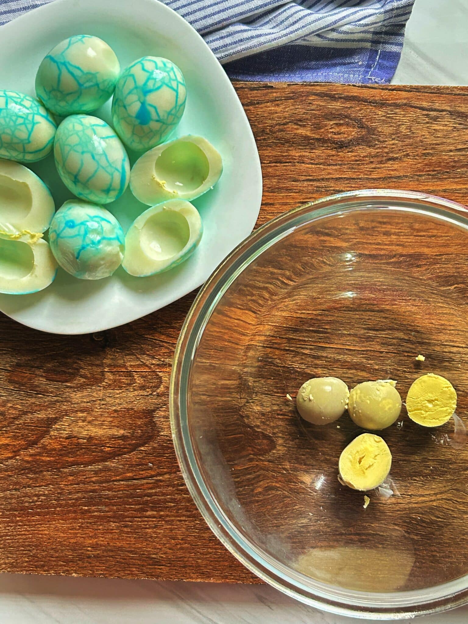 Halved boiled eggs with yolks being scooped into a bowl Halved boiled eggs with yolks being scooped into a bowl