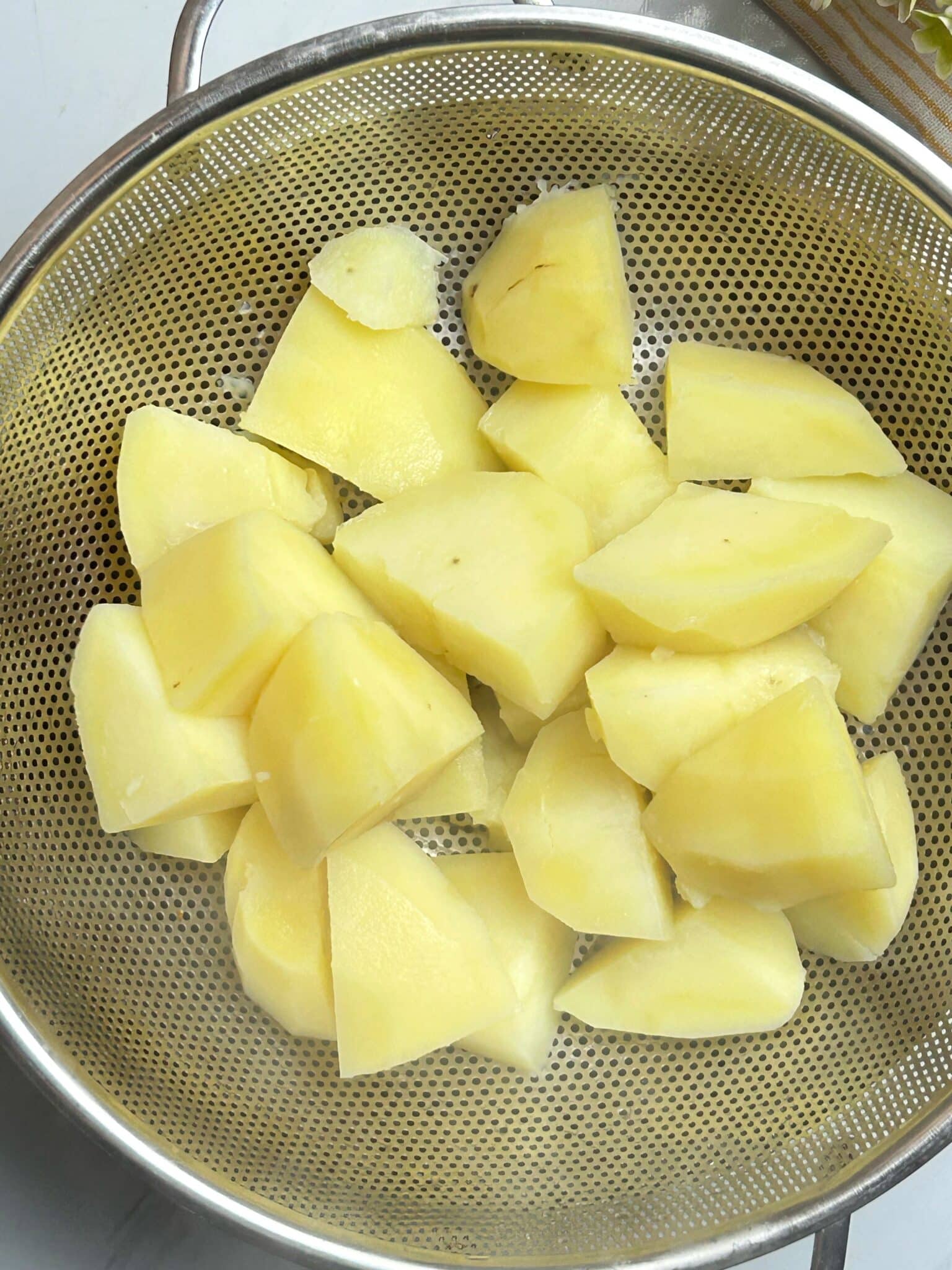 Draining boiled potatoes and returning them to the pot Draining boiled potatoes and returning them to the pot