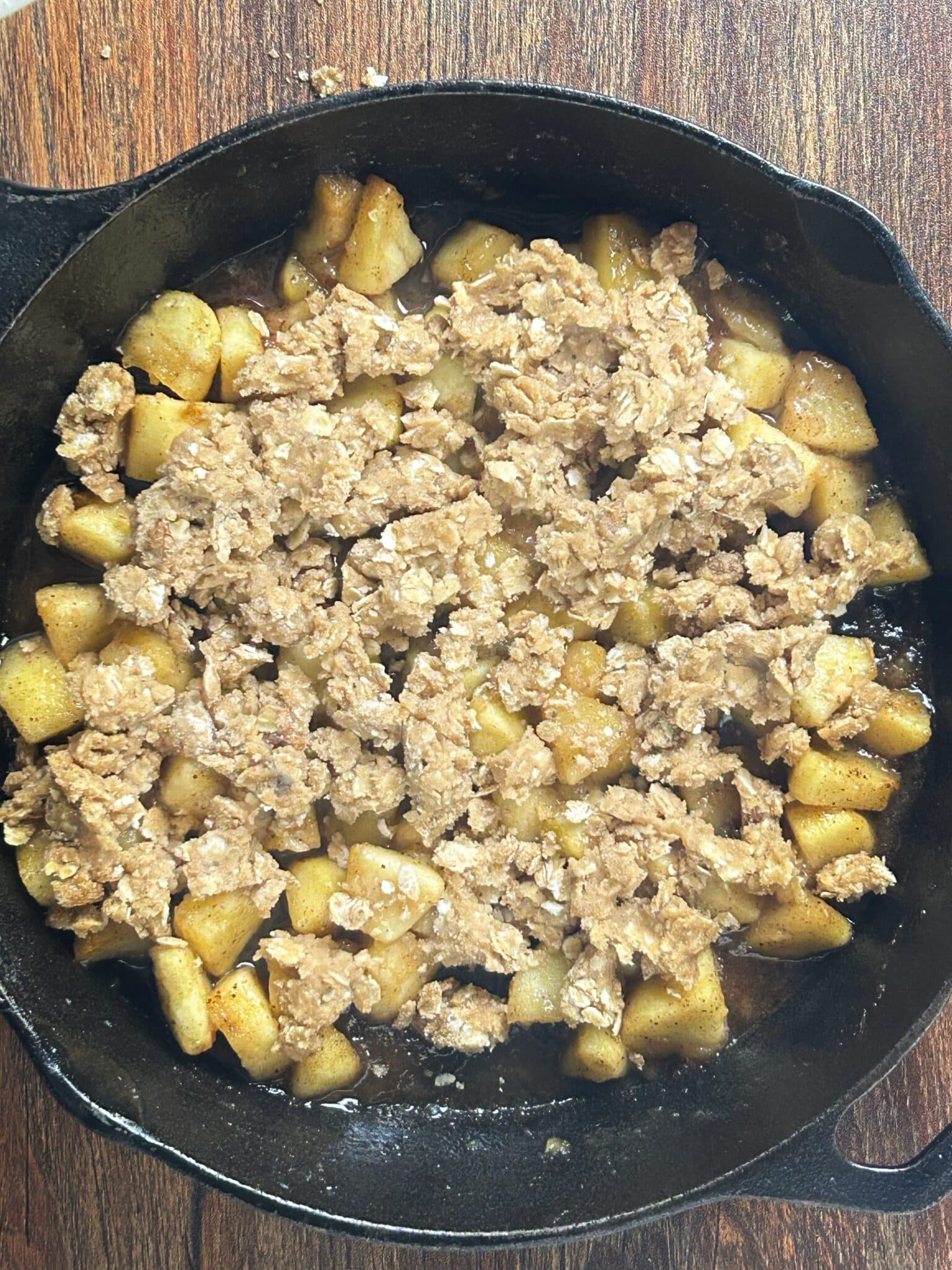Spreading the oat crumble evenly over the apple crisp Spreading the oat crumble evenly over the apple crisp