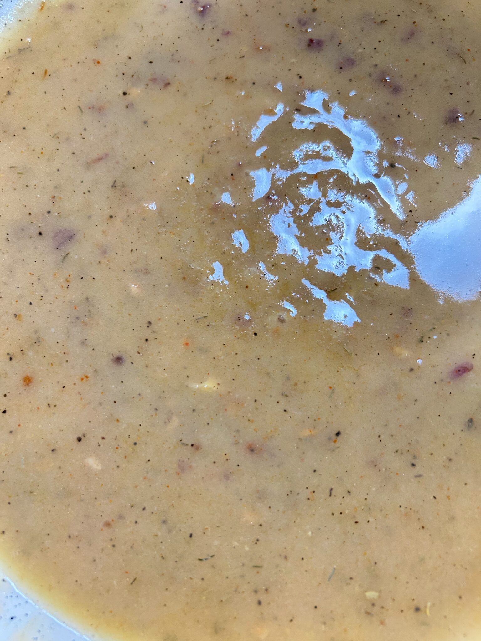 Adding salt, black pepper, and thyme to the gravy and stirring to combine Adding salt, black pepper, and thyme to the gravy and stirring to combine