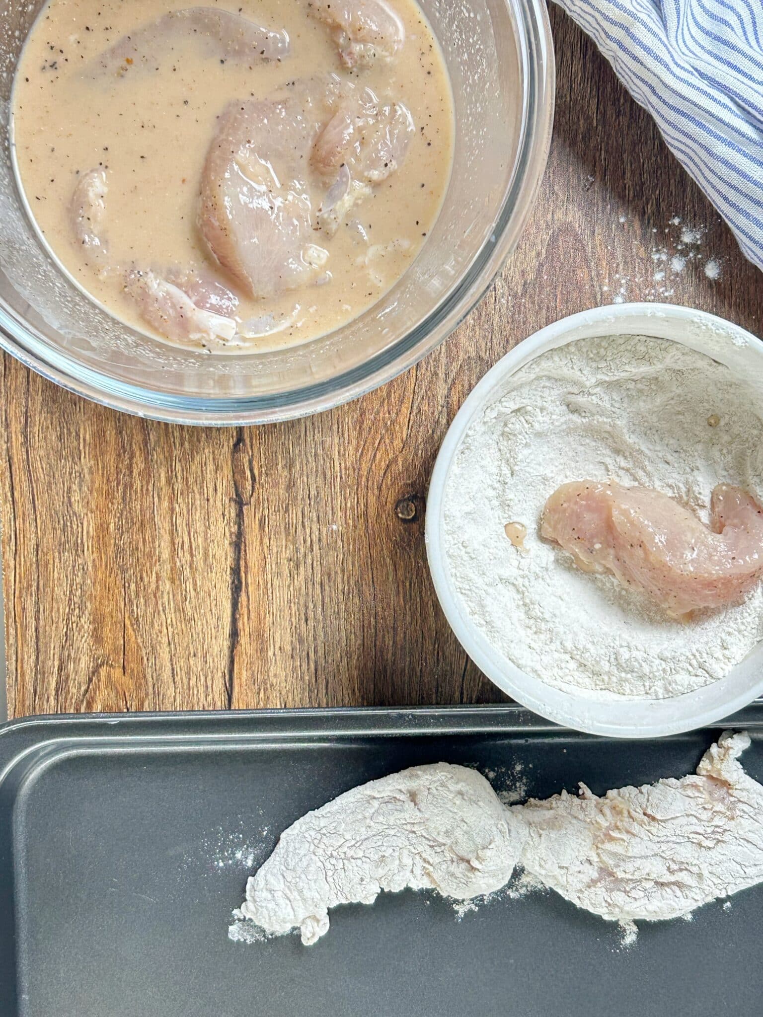Chicken strips pressed into flour and spice mixture for coating Chicken strips pressed into flour and spice mixture for coating