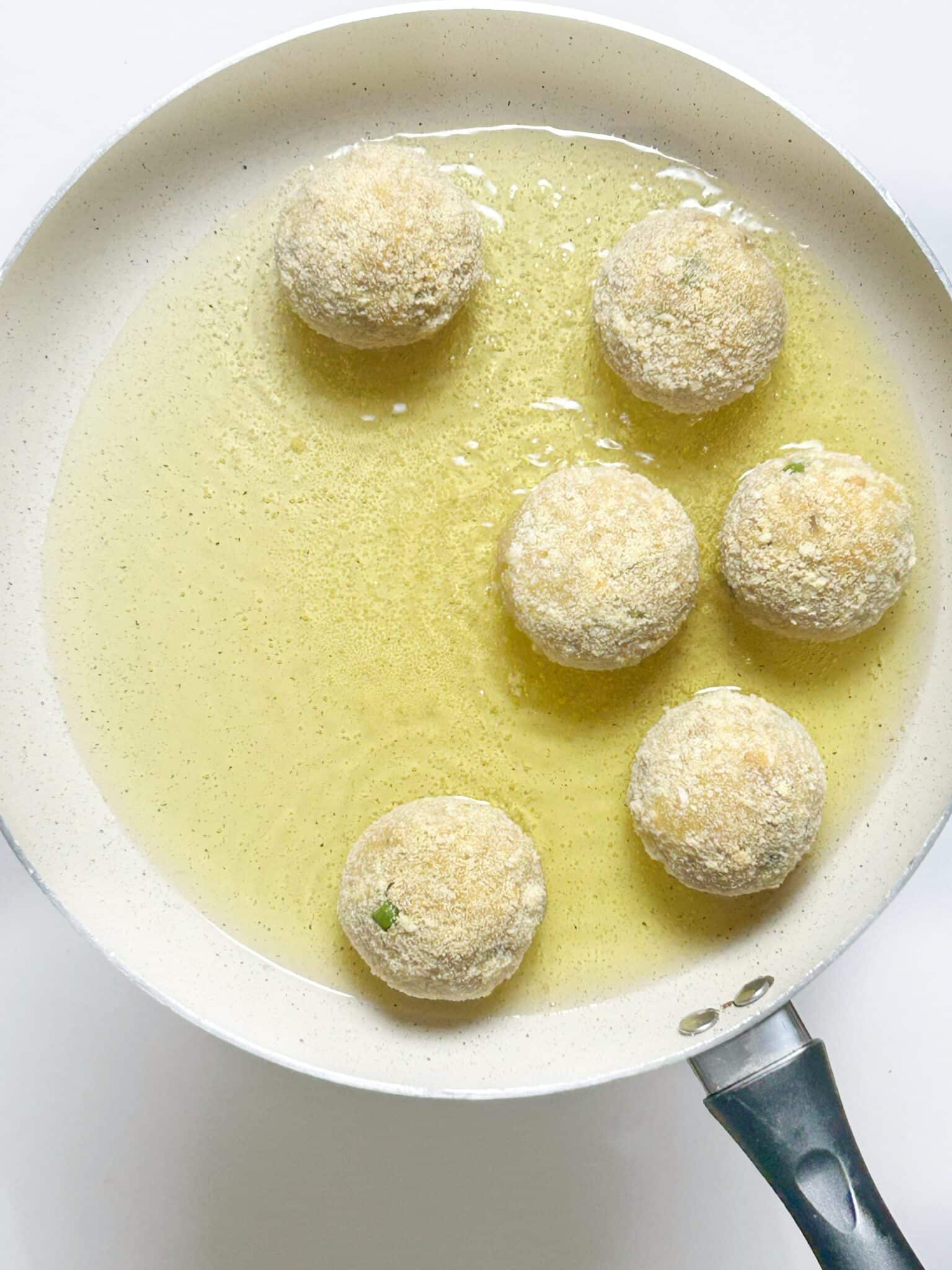Cheese balls frying in hot oil until golden brown Cheese balls frying in hot oil until golden brown