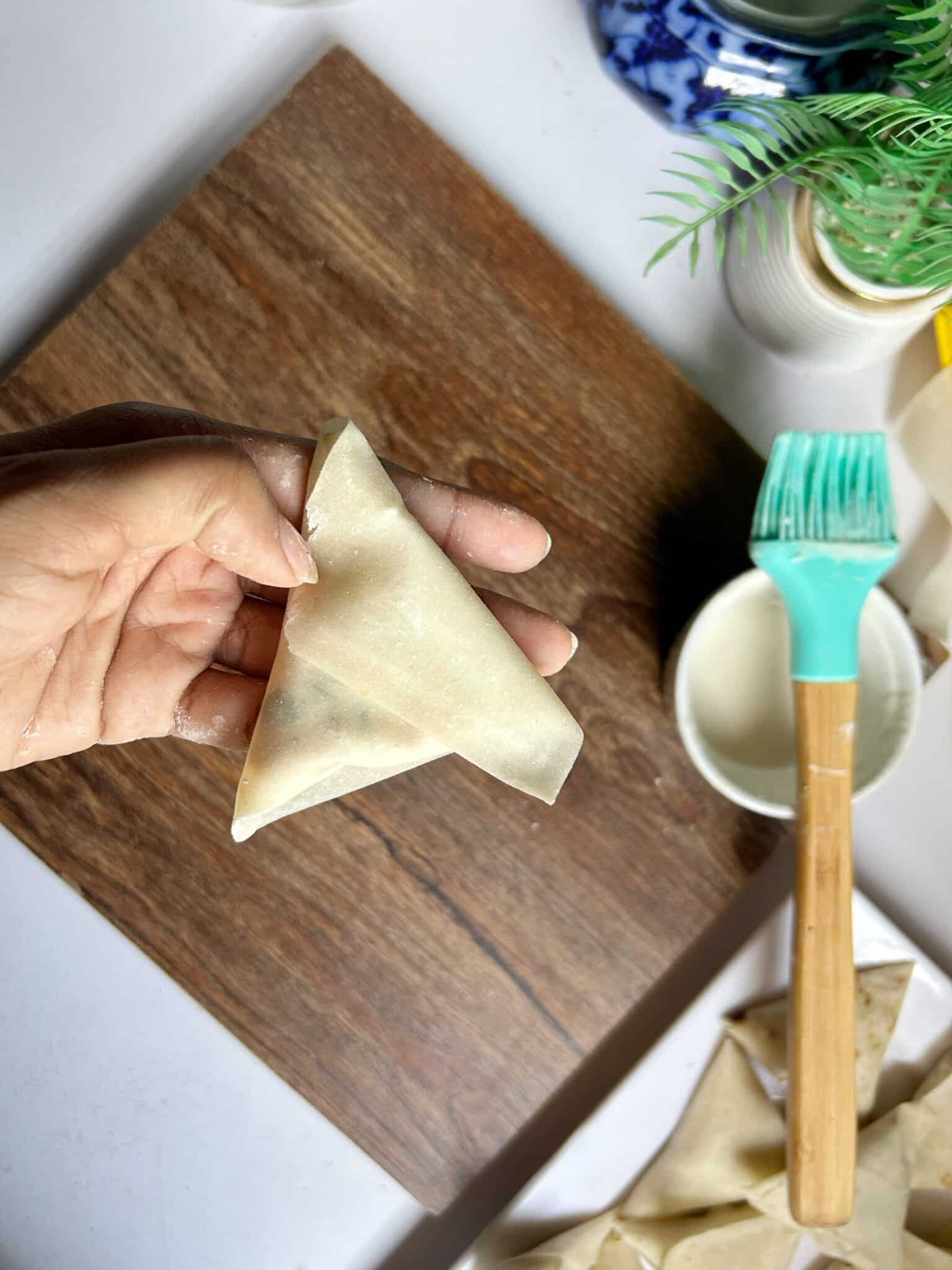 Sealing Chicken Malai Boti samosa edges tightly Sealing Chicken Malai Boti samosa edges tightly