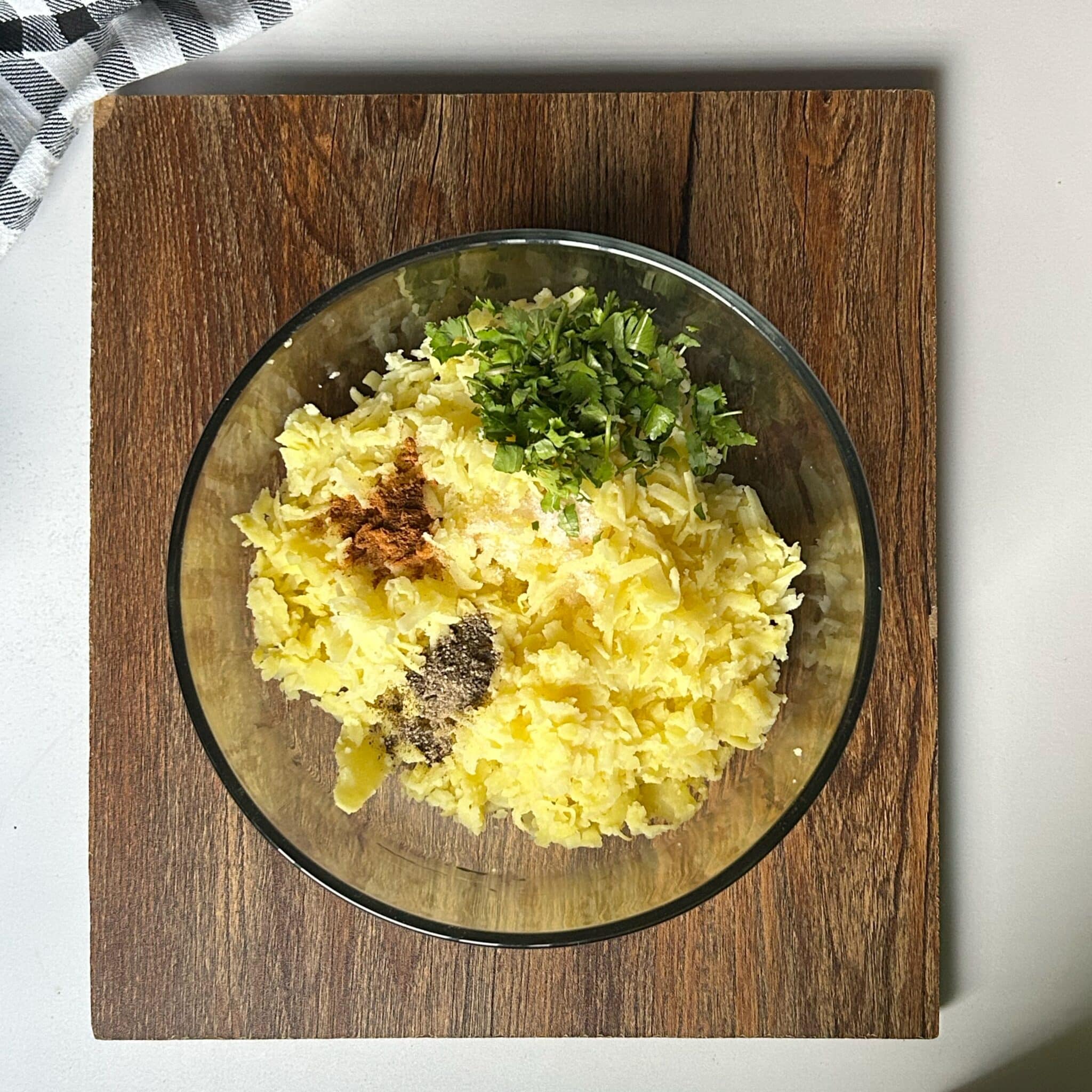 Mashed potatoes mixed with salt, black pepper, paprika, and parsley in a bowl Mashed potatoes mixed with salt, black pepper, paprika, and parsley in a bowl