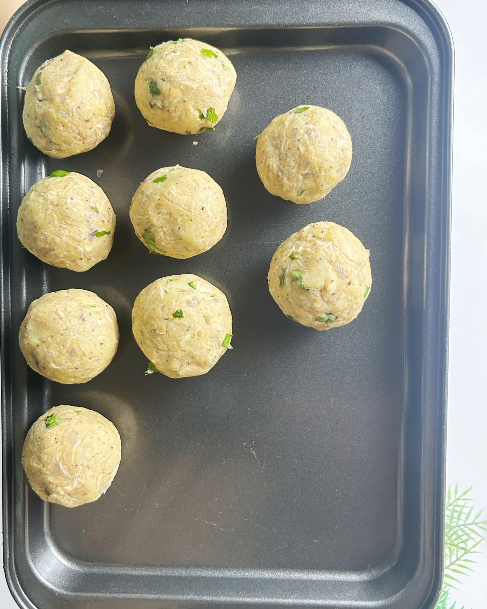Rolling stuffed potato mixture into smooth cheese balls Rolling stuffed potato mixture into smooth cheese balls