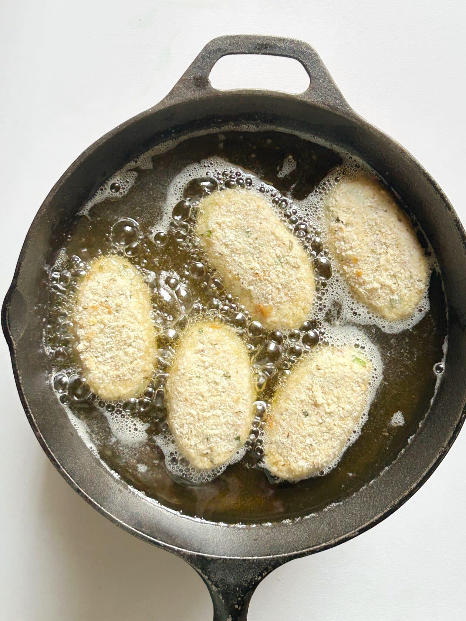 Frying croquettes in oil on medium heat until golden brown on all sides Frying croquettes in oil on medium heat until golden brown on all sides