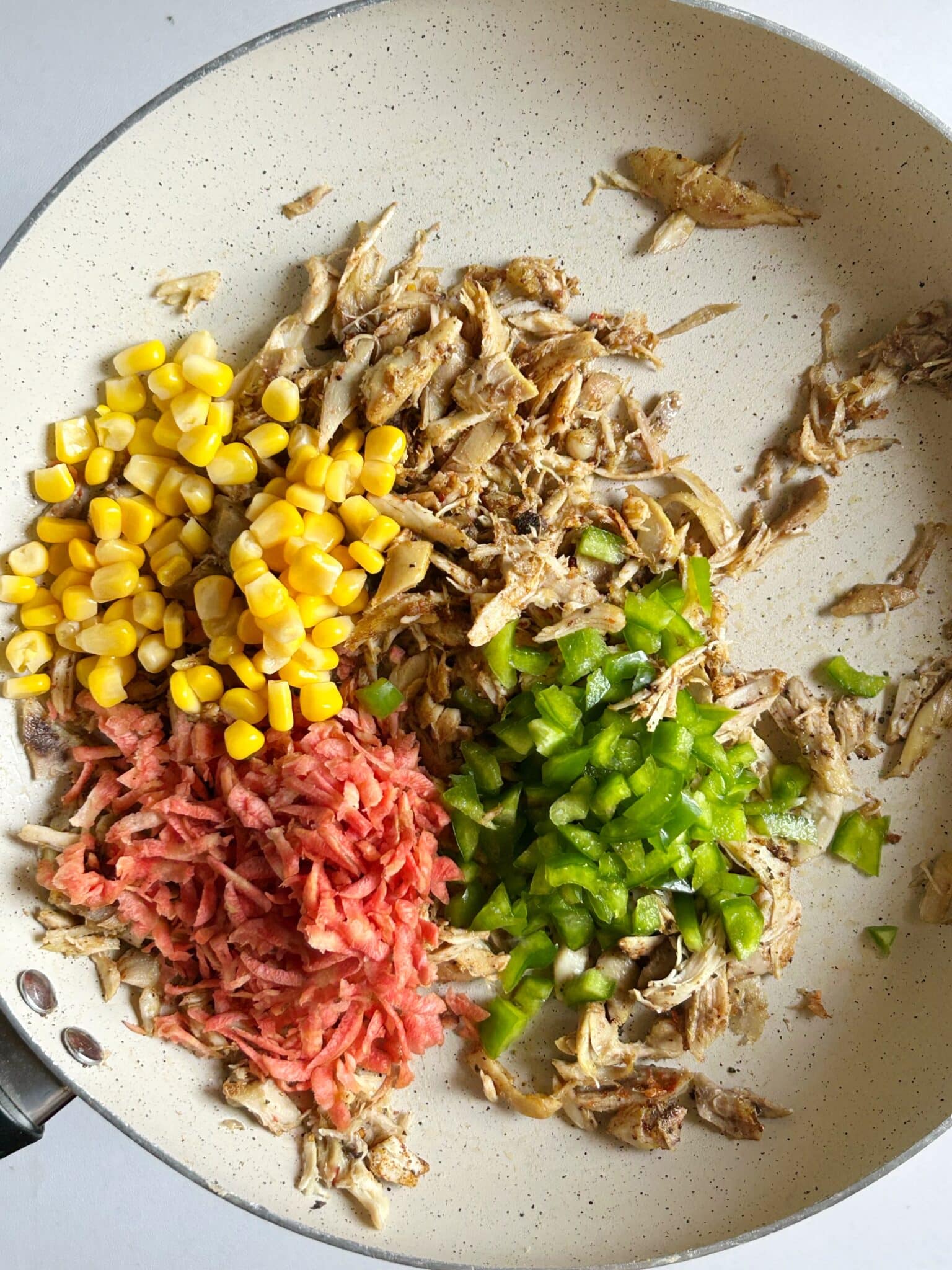 Adding vegetables to chicken filling Adding vegetables to chicken filling
