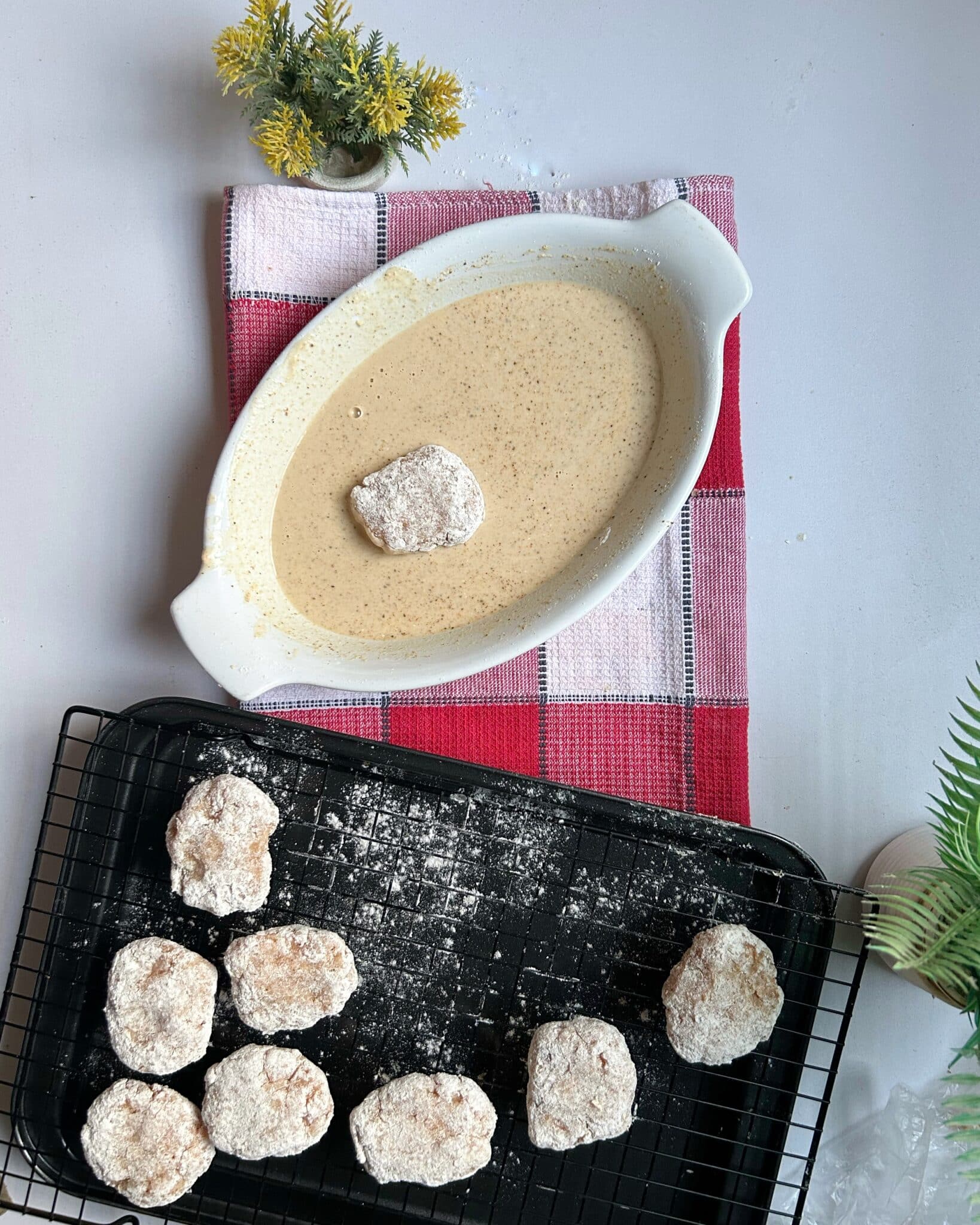 Dipping coated chicken nuggets into wet batter before frying for extra crispiness Dipping coated chicken nuggets into wet batter before frying for extra crispiness