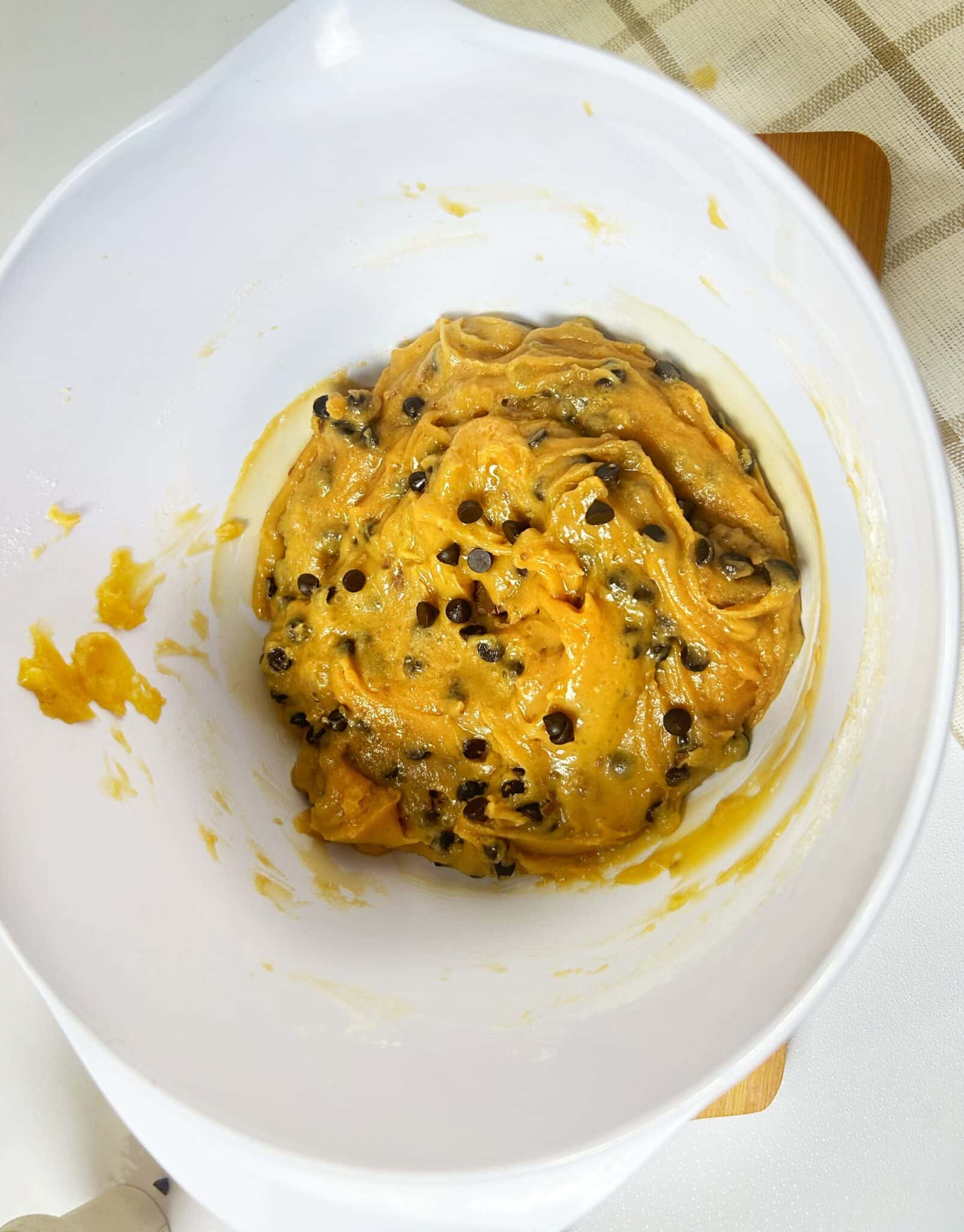 Mixing flour and baking powder with wet ingredients to form cookie dough and folding in chocolate chips