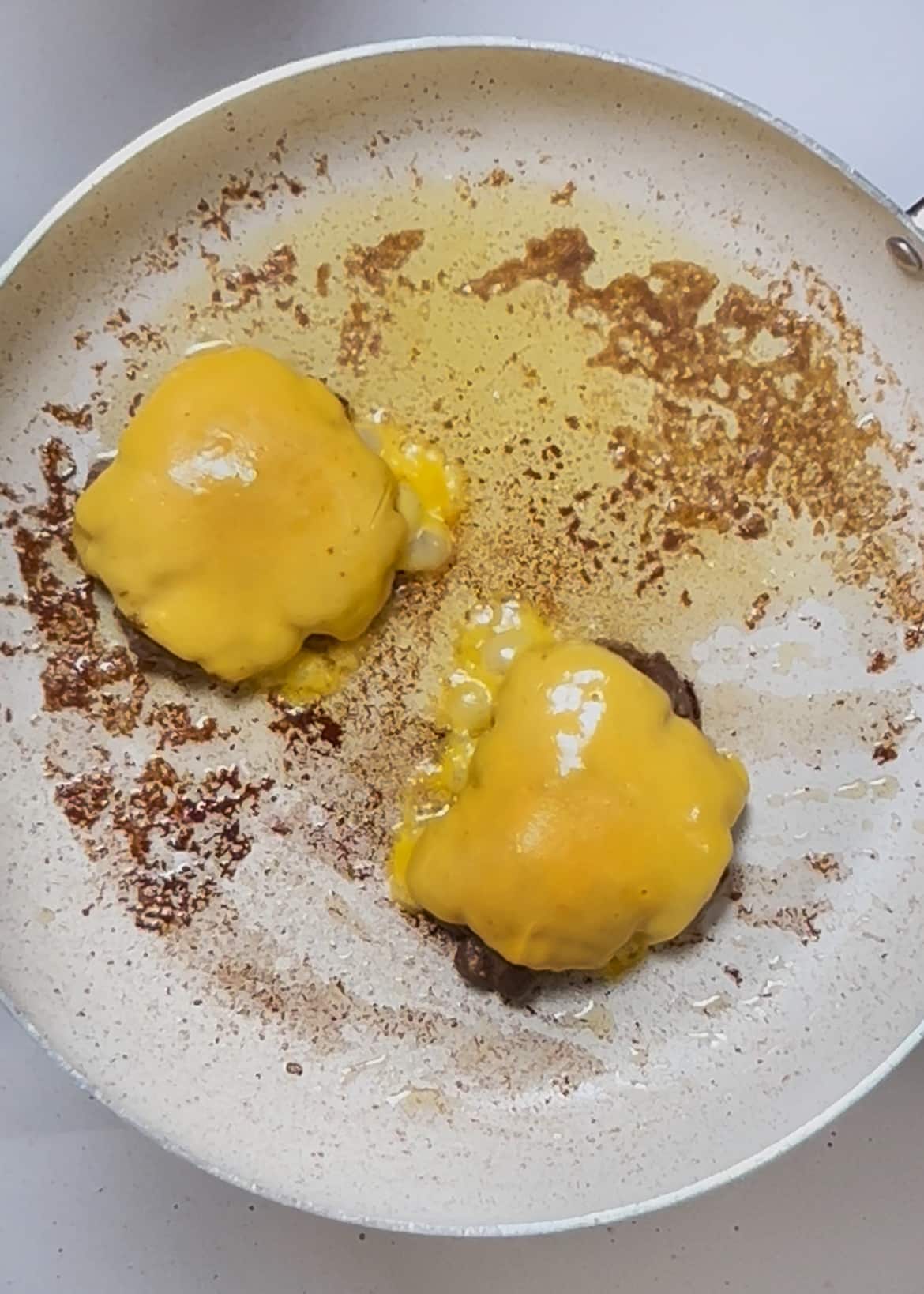 adding cheese to burger patties