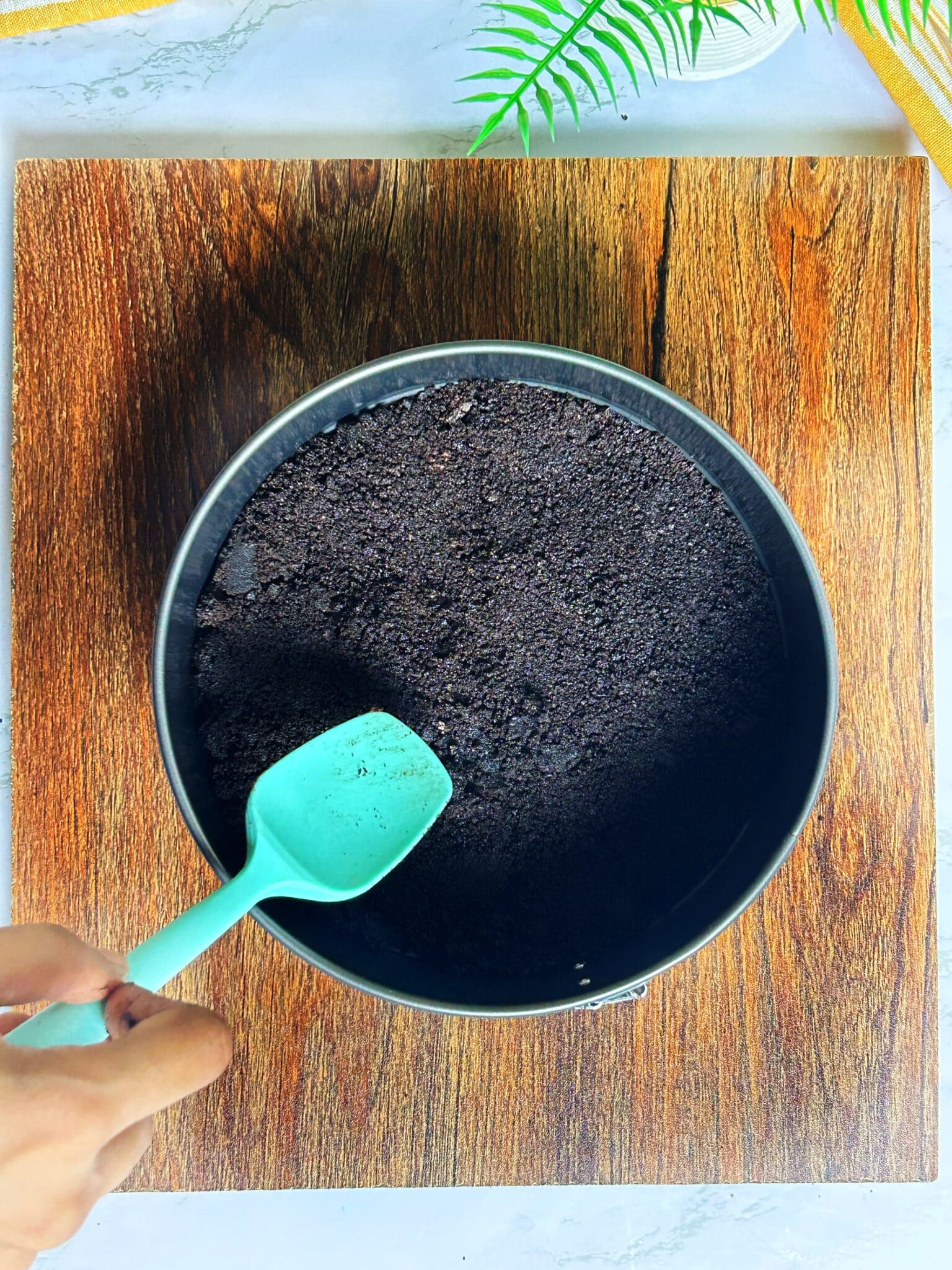 pressing crushed oreo mixture in a springform pan